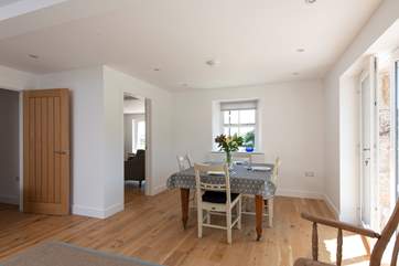 Looking from the kitchen to the dining area with the sitting-room on the left.