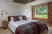 Bedroom 1 offers this fabulous super-king size bed with views out over the garden and into the woodland.