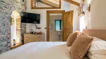 The beautiful stone walls and original house features have been lovingly maintained and showcased in this beautiful bedroom.