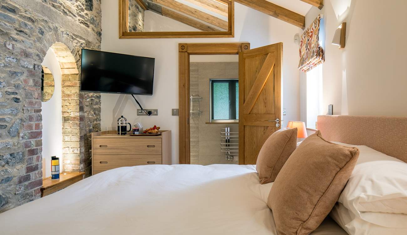 The beautiful stone walls and original house features have been lovingly maintained and showcased in this beautiful bedroom.