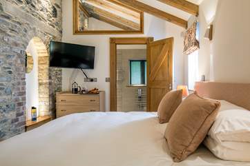 The beautiful stone walls and original house features have been lovingly maintained and showcased in this beautiful bedroom.