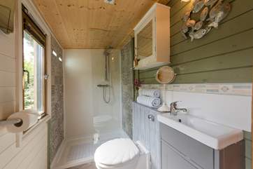 An equally attractive space, with walk-in shower cubicle, WC and wash-basin (please mind your head with the low ceiling).