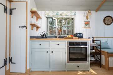 The small but perfectly formed kitchen includes an electric cooker, fridge and sweet Belfast sink.