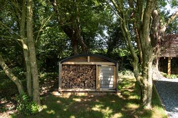 A supply of logs for the wood-burner is on-hand.
