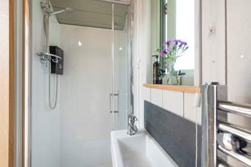 With heated towel rail, WC, small wash-basin and walk-in shower cubicle.