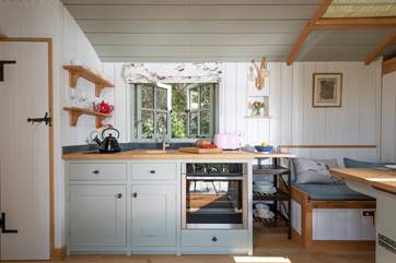 The small but perfectly formed kitchen includes an electric cooker, fridge and sweet Belfast sink.