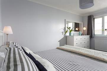 The master bedroom is styled in lovely greys and whites.