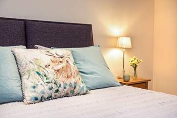 The beds are adorned with lovely linens and cushions.