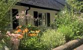 The Coach House is embraced with beautiful flower borders and has its own beautiful gardens, set within the grounds of a country house. There are a couple of steps down to the front door and then one up.  - Thumbnail Image