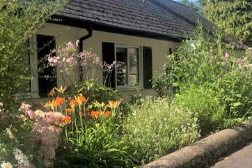 The Coach House is embraced with beautiful flower borders and has its own beautiful gardens, set within the grounds of a country house. There are a couple of steps down to the front door and then one up.