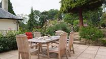 The stone terrace has beautifully planted borders and French windows from the living-area, lead straight out onto it. You can see the corner of the owner's home next door - The Coach House is on a higher level and tucked behind it.