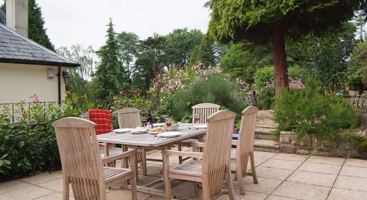 The stone terrace has beautifully planted borders and French windows from the living-area, lead straight out onto it. You can see the corner of the owner's home next door - The Coach House is on a higher level and tucked behind it.