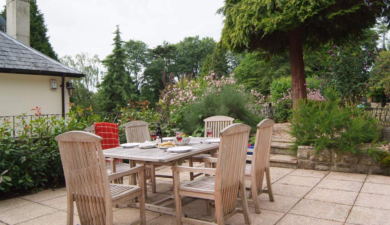 The stone terrace has beautifully planted borders and French windows from the living-area, lead straight out onto it. You can see the corner of the owner's home next door - The Coach House is on a higher level and tucked behind it.