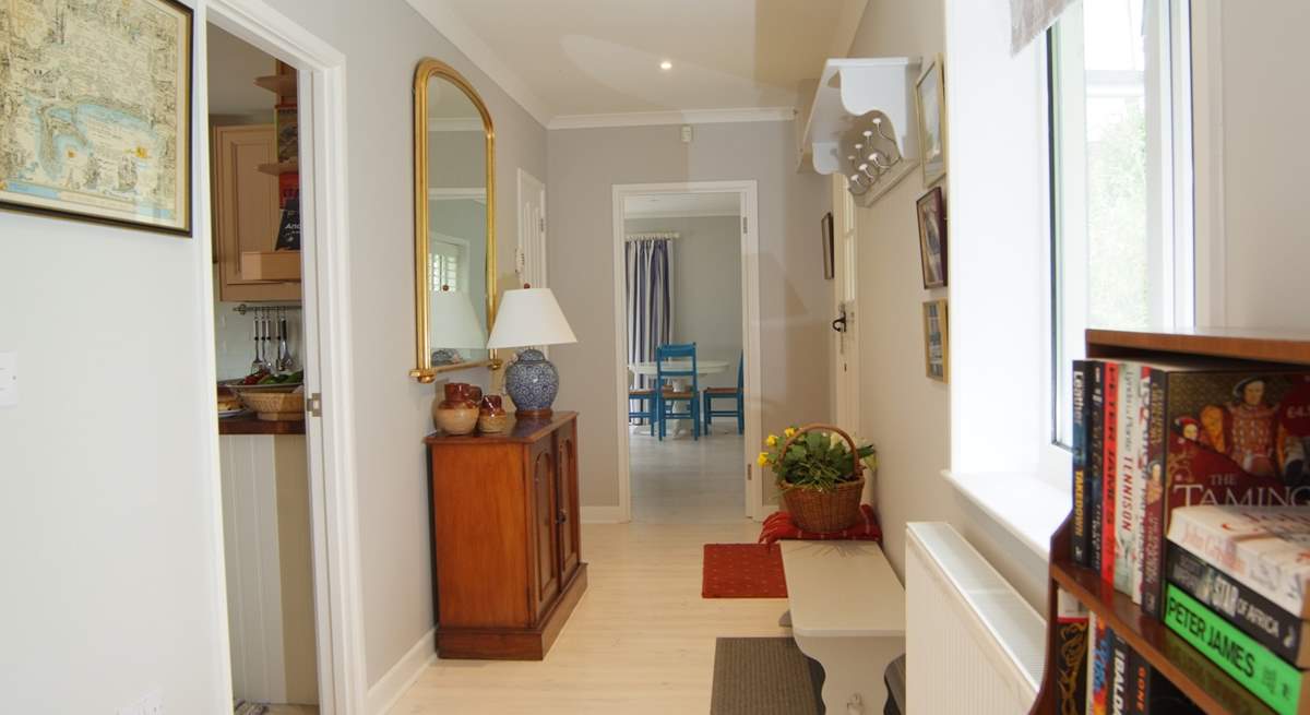 Looking along the length of the wide hallway with the kitchen off to the left and the sitting/dining-room straight ahead.