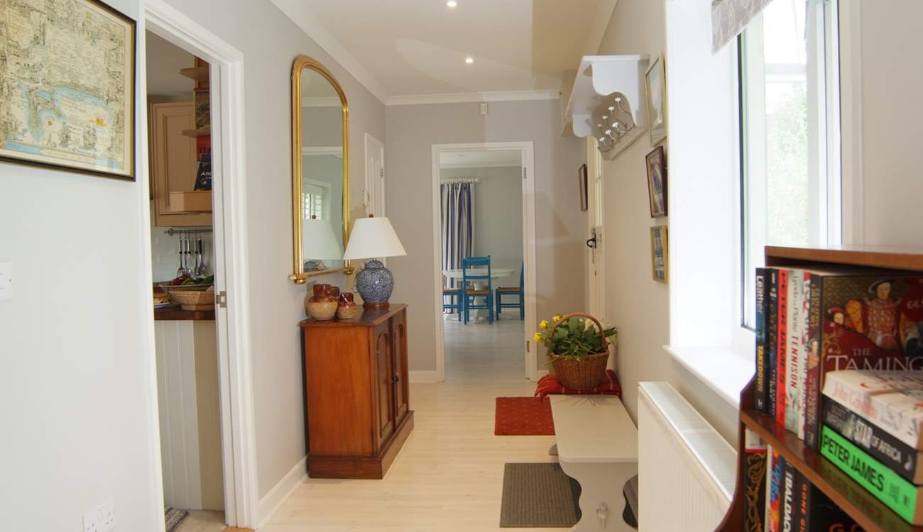 Looking along the length of the wide hallway with the kitchen off to the left and the sitting/dining-room straight ahead.