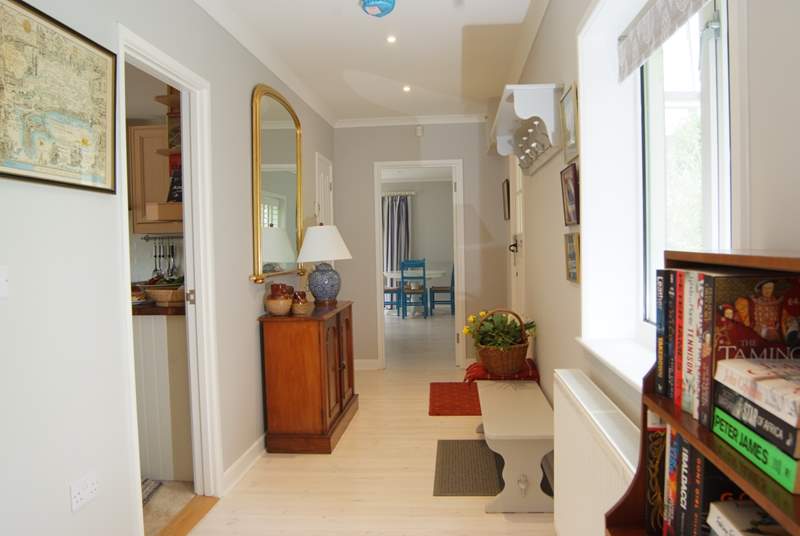 Looking along the length of the wide hallway with the kitchen off to the left and the sitting/dining-room straight ahead.