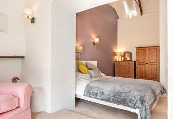 The main bedroom has vaulted ceilings and a small sitting-area in which to relax.