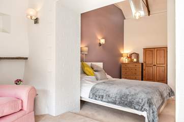 The main bedroom has vaulted ceilings and a small sitting-area in which to relax.