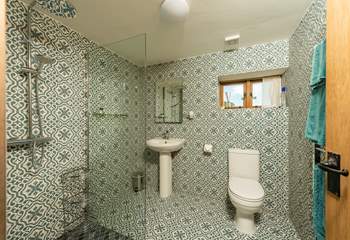 The spacious en suite with its walk-in shower and wonderful patterned tiles. A shower chair is provided for those who wish to use one.