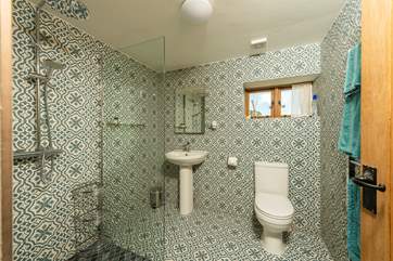 The spacious en suite with its walk-in shower and wonderful patterned tiles. A shower chair is provided for those who wish to use one.