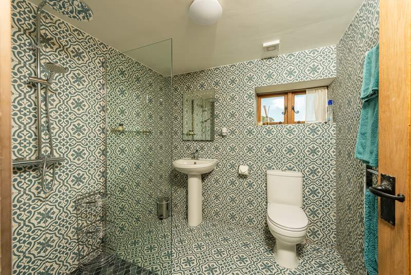 The spacious en suite with its walk-in shower and wonderful patterned tiles. A shower chair is provided for those who wish to use one.