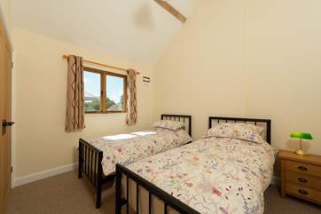 The pretty twin bedroom looks out to the front of the barn.