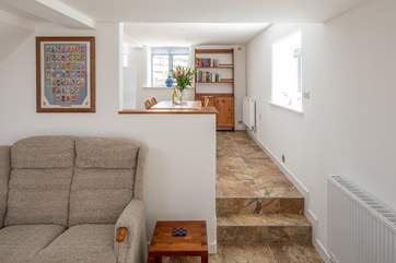 The sitting-room leads up into the kitchen via two steps.