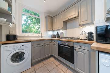 The contemporary kitchen overlooks the wonderful garden with exotic plants and fig tree.
