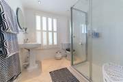 The shared family bathroom has a large shower cubicle.