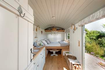 The bed cleverly folds down from the wall to sit atop the dining table.
