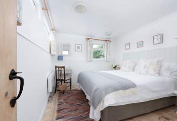 The main bedroom on the second floor has a king-size bed.