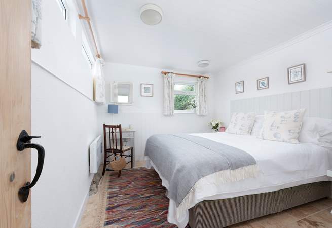 The main bedroom on the second floor has a king-size bed.