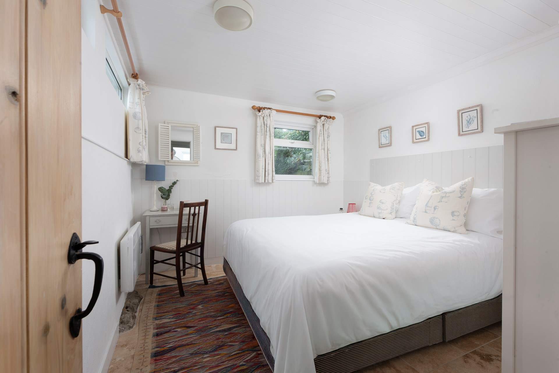 The main bedroom on the second floor has a king-size bed.