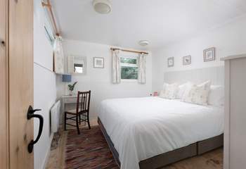 The main bedroom on the second floor has a king-size bed.