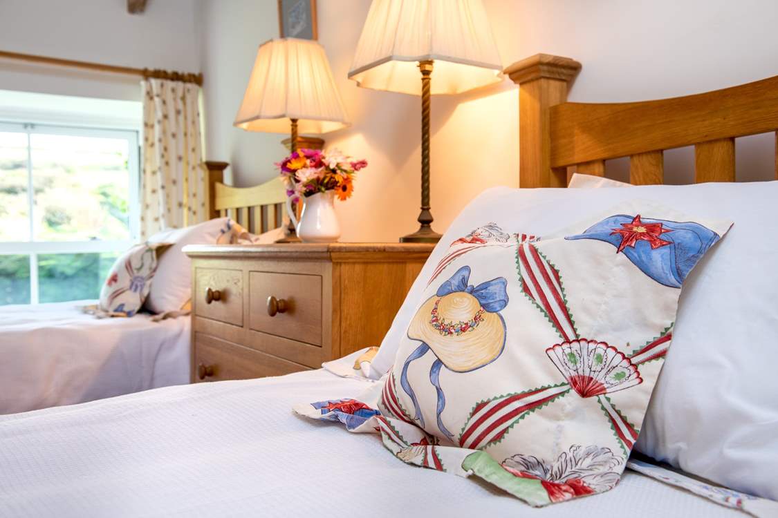 Pretty cushions and linens in bedroom 2.