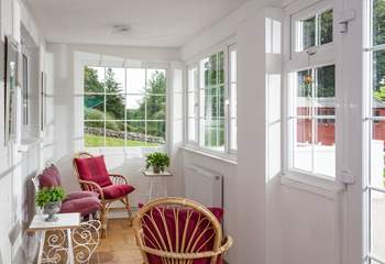 The sunny porch overlooks the garden. Open up the doors, and you can sit and listen to the morning bird song. (There is a little step leading into the kitchen area) 