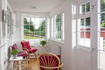 The sunny porch overlooks the garden. Open up the doors, and you can sit and listen to the morning bird song. (There is a little step leading into the kitchen area)