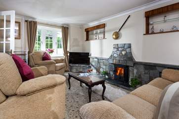 The cosy sitting-room with its toasty wood-burner makes this a perfect retreat all year round. There is a little step leading from the hallway to the front door.