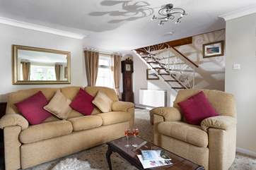 Wooden polished open-tread stairs lead up to the first floor from the sitting-room.
