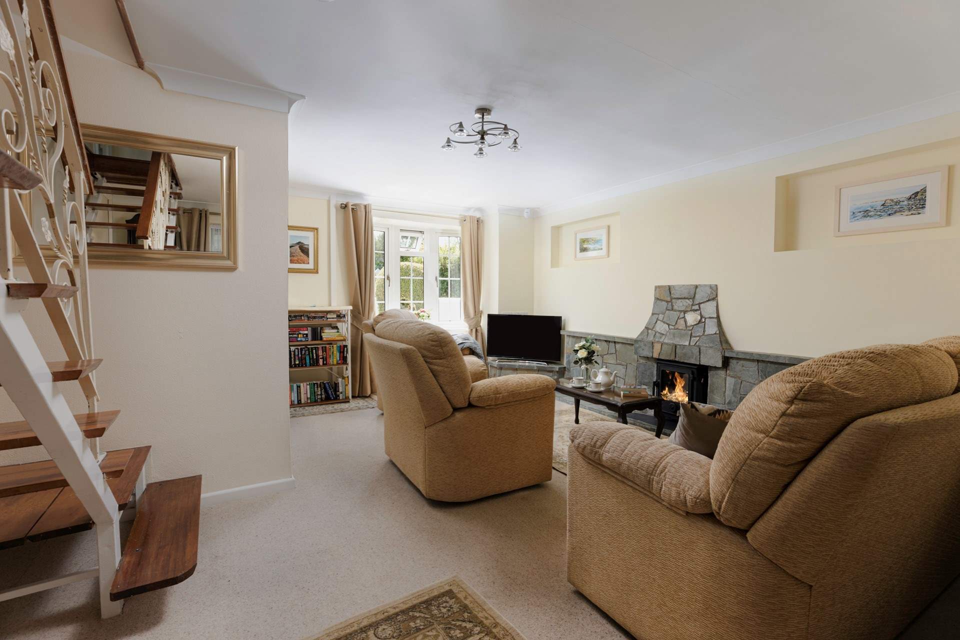 Wooden polished open-tread stairs lead up to the first floor from the sitting-room.