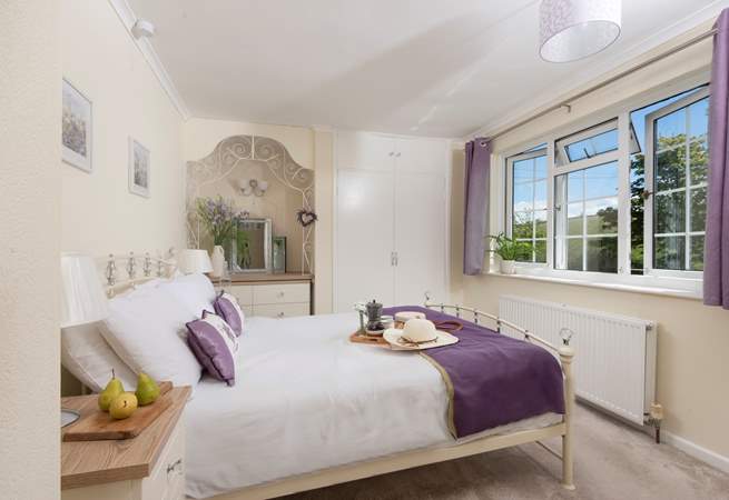 The pretty double bedroom looks over rolling countryside. 