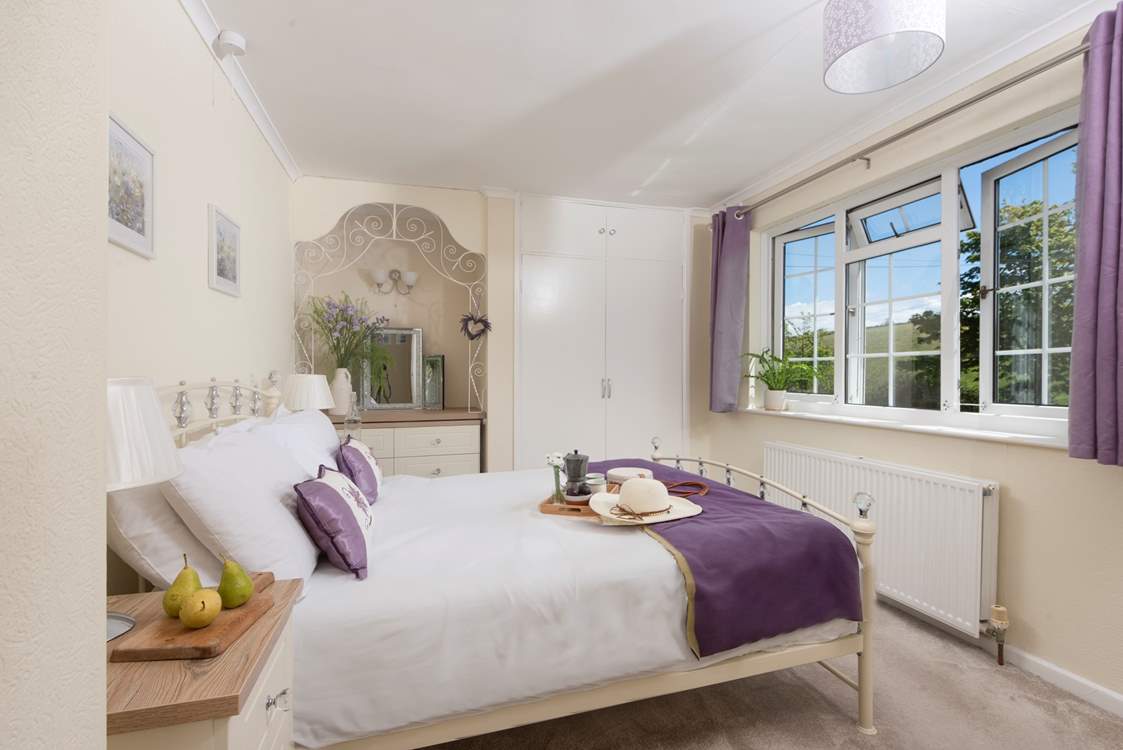 The pretty double bedroom looks over rolling countryside.