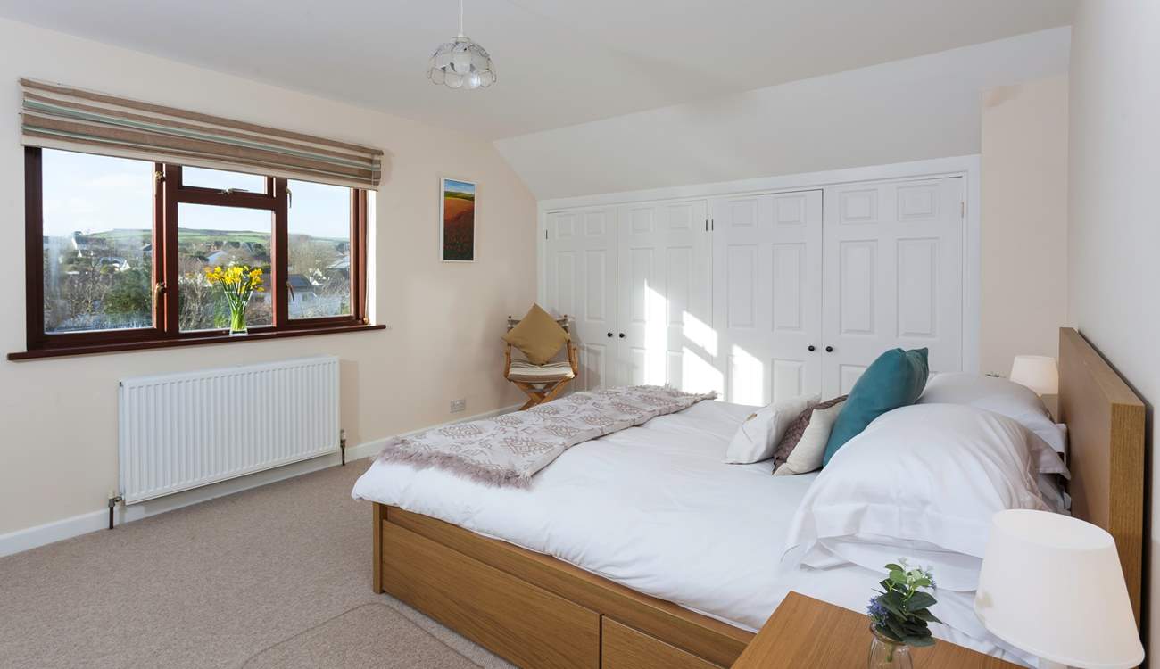 The master bedroom is located on the first floor, and overlooks the pretty rear garden.
