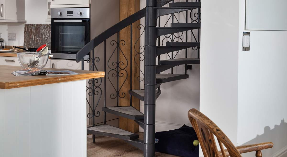 The spiral stairs lead up to the principal bedroom, and under the stairs is the perfect spot for your four-legged friend. 