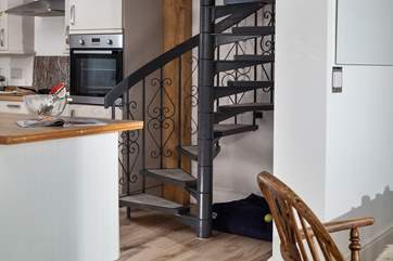 The spiral stairs lead up to the master bedroom, and under the stairs is the perfect spot for your four-legged friend.