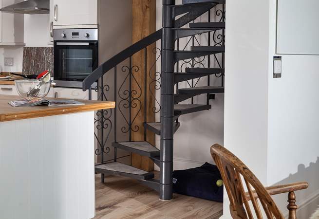 The spiral stairs lead up to the principal bedroom, and under the stairs is the perfect spot for your four-legged friend. 