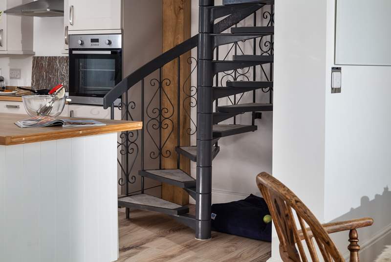 The spiral stairs lead up to the master bedroom, and under the stairs is the perfect spot for your four-legged friend. 