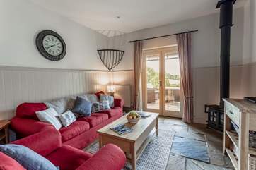The comfortable living space with wood-burning stove and French doors opening onto the private decking area.