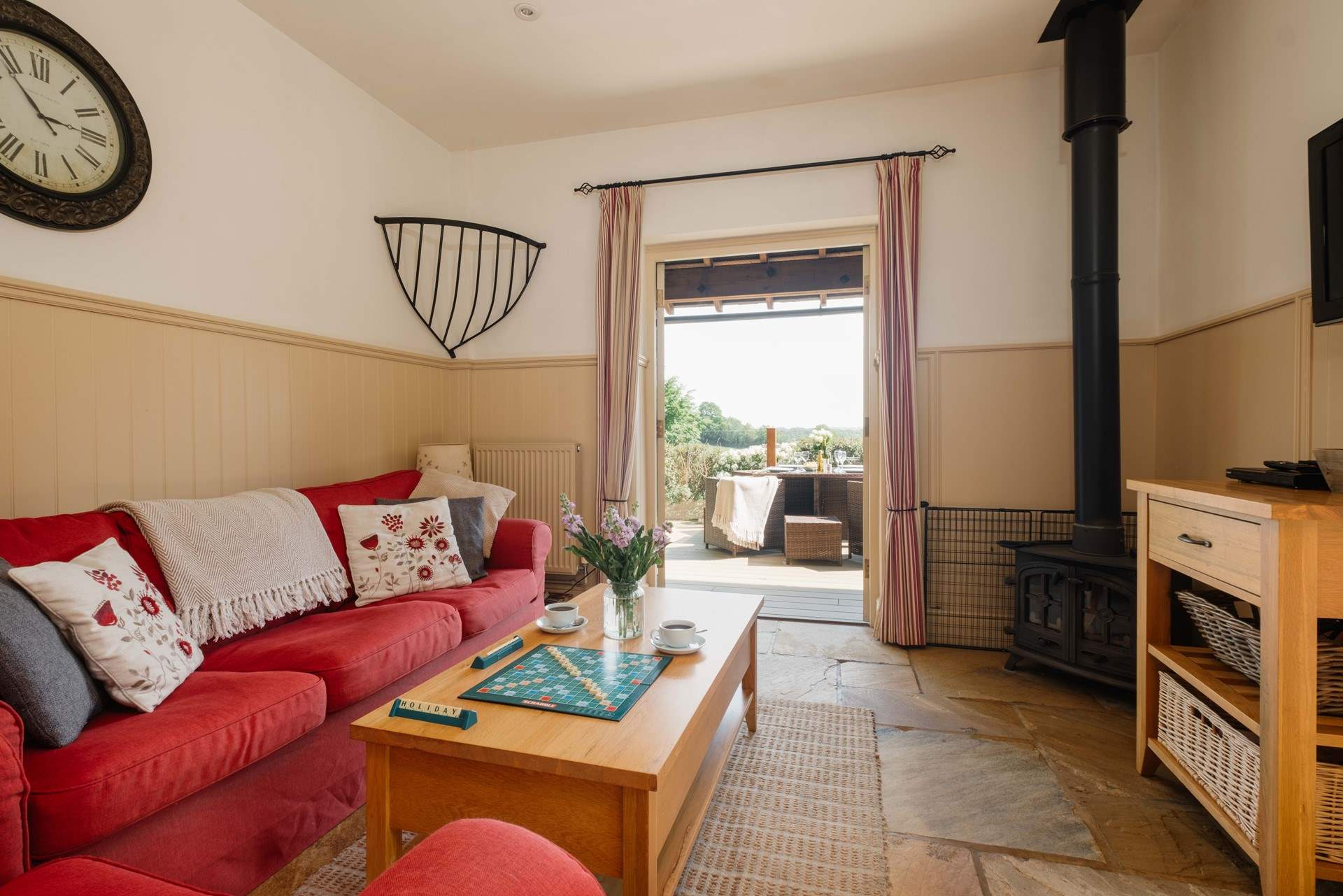 The comfortable living space with wood-burning stove and French doors opening onto the private decking area.