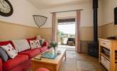 The comfortable living space with wood-burning stove and French doors opening onto the private decking area. - Thumbnail Image